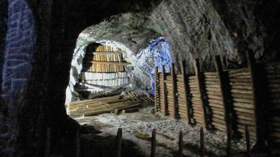 Eine unterirdische Höhle mit Holzkonstruktionen und einer Holdleiter.