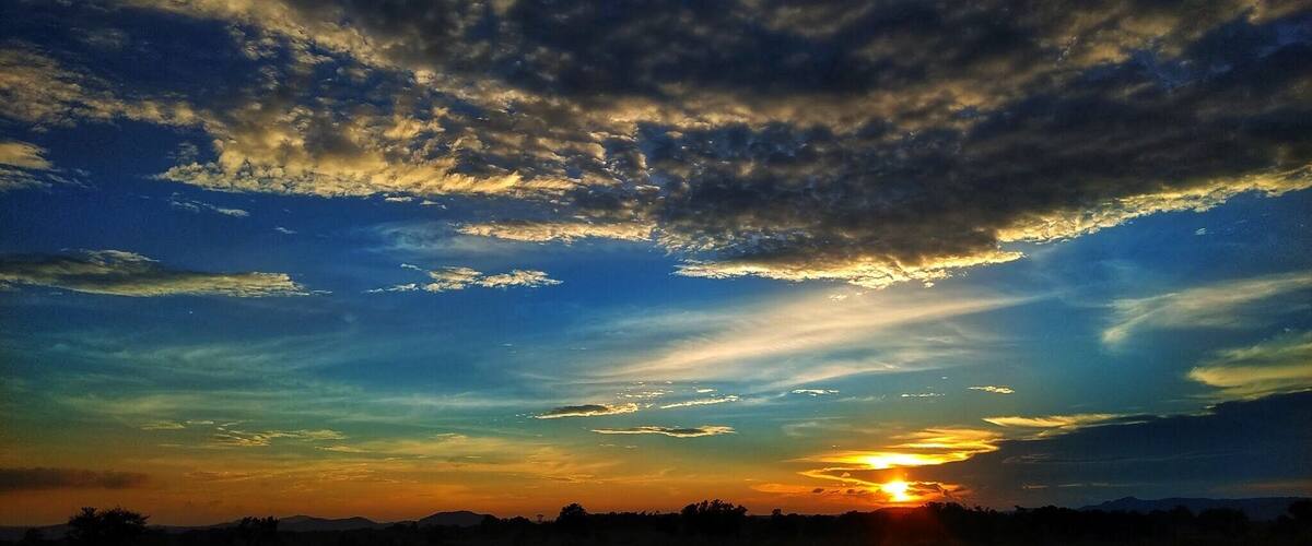 A sunset over a flat landscape with a road in the foreground.
