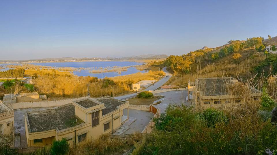 A lakeside village with buildings and a winding road.