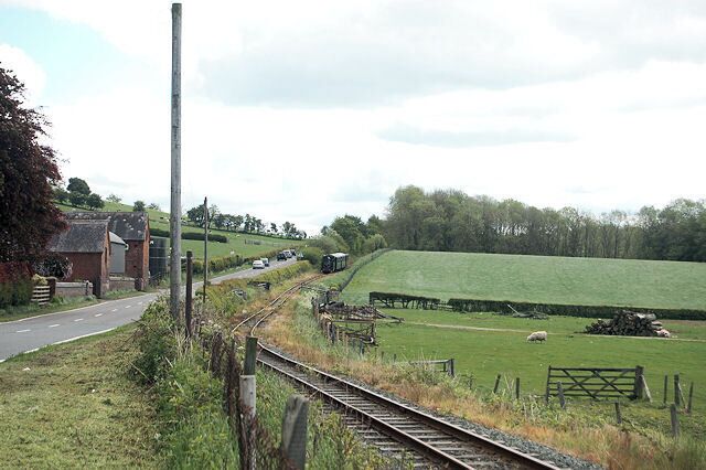 View east along A 458 The 11-15 from Welshpool approaches on the railway