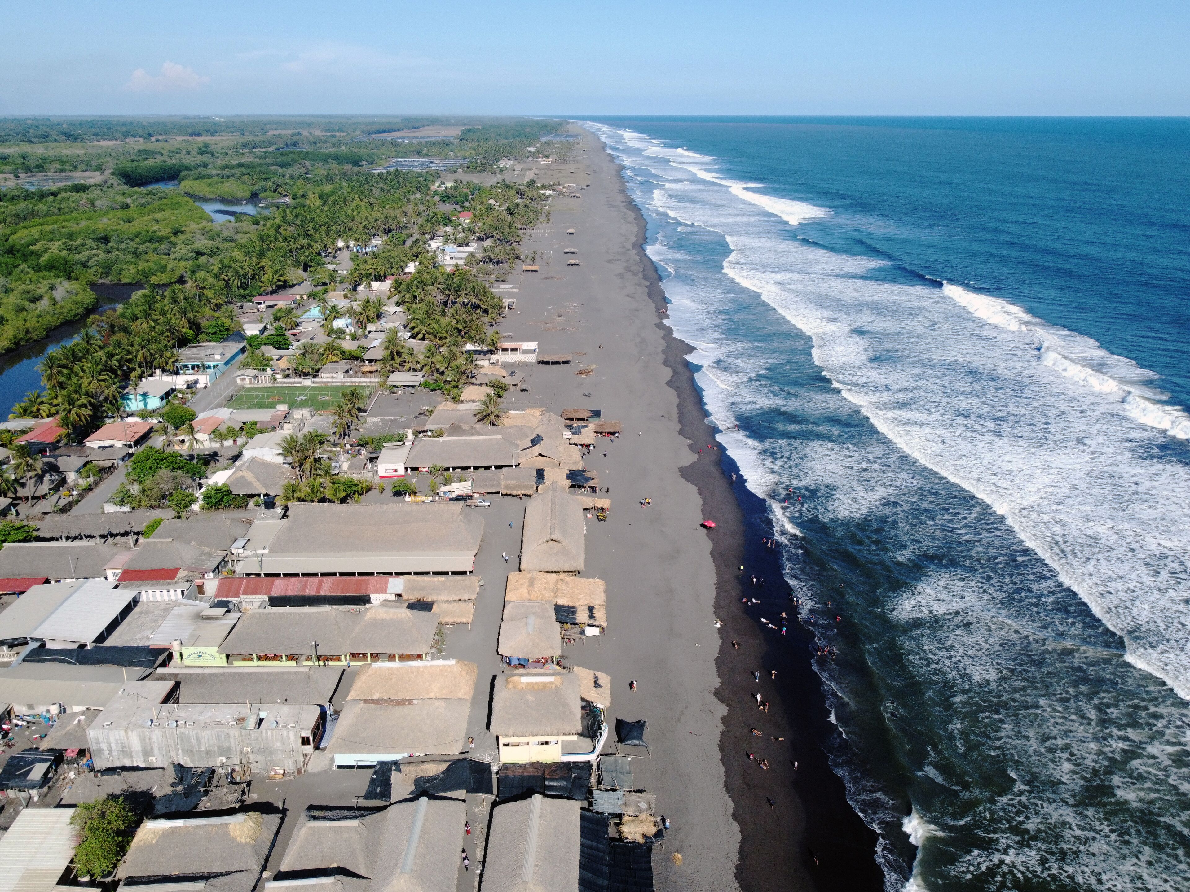 A coastal town with a beach, buildings, and a river.