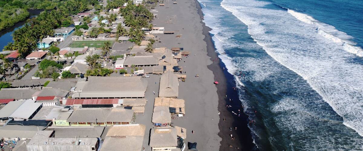 A coastal town with a beach, buildings, and a river.