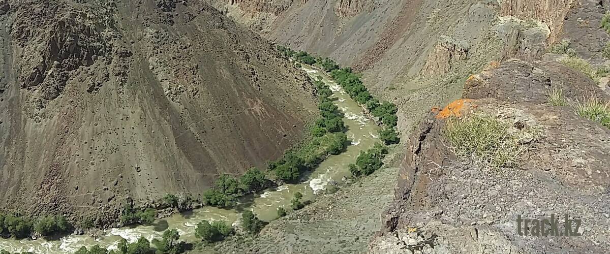 A rugged mountain landscape with a winding river and sparse vegetation.