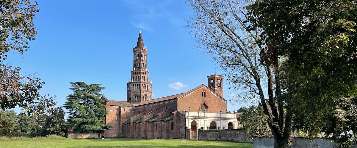 Una iglesia histórica con un alto campanario y un edificio adyacente más pequeño.