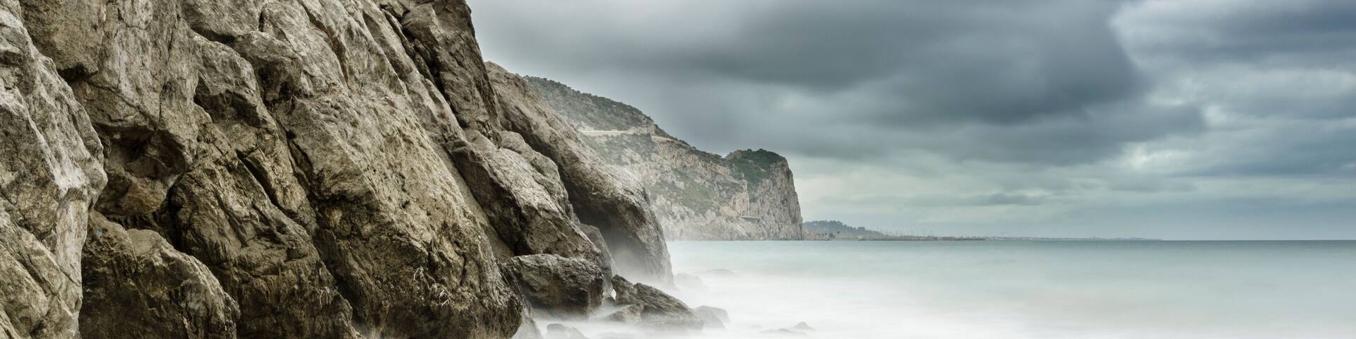 Playa de la cala Vallcarca en el parque natural del Garraf con nubes de tormenta (Cataluña, España)