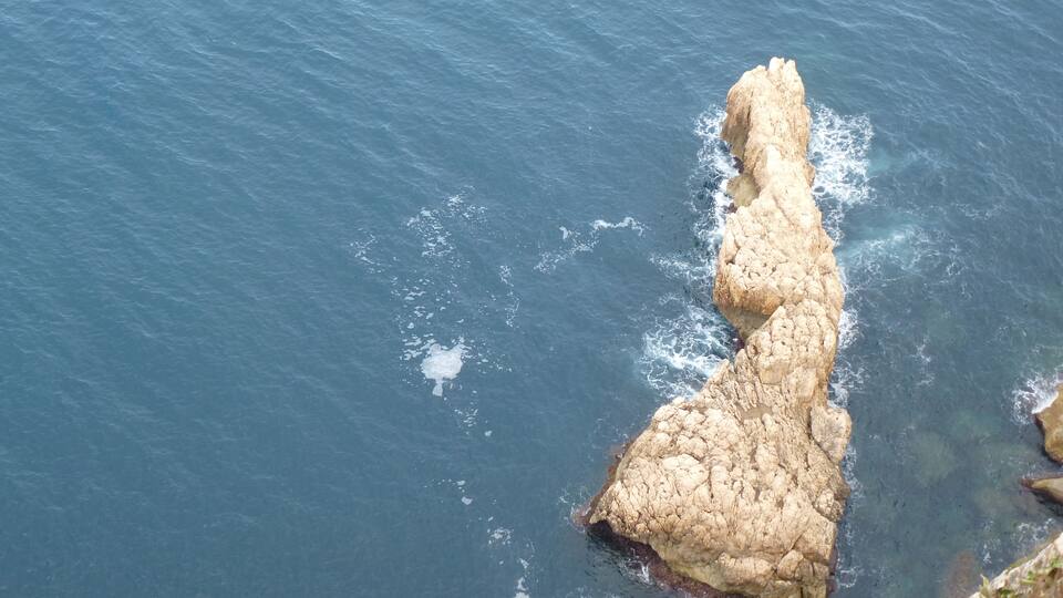 A rocky coastline with waves crashing against the shore.