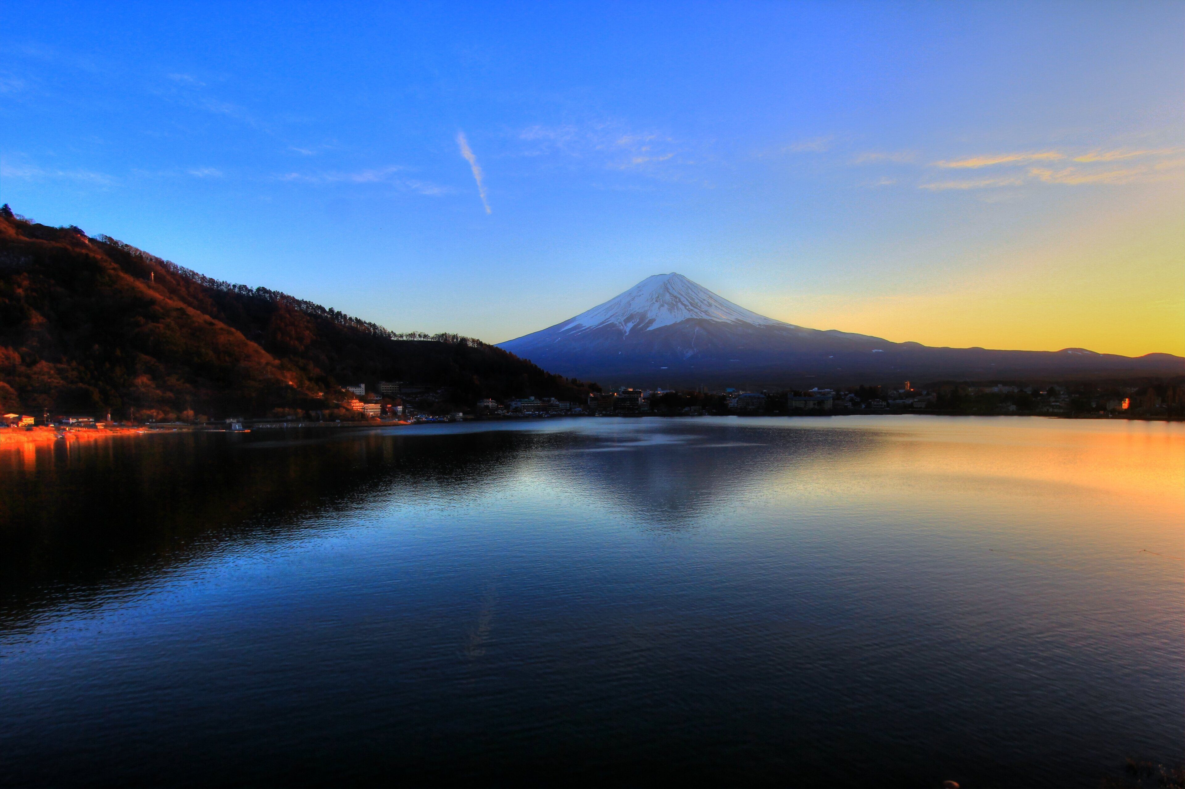 A calm lake with a mountain in the background.
