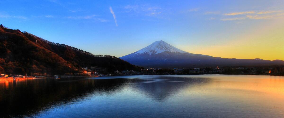 A calm lake with a mountain in the background.