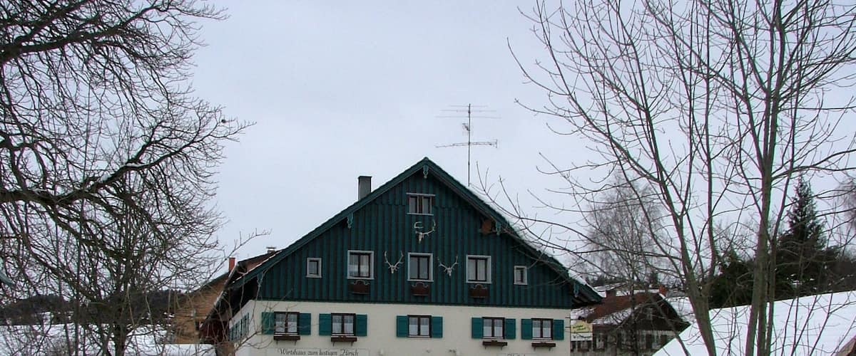 A traditional Alpine-style building with snow-covered surroundings.