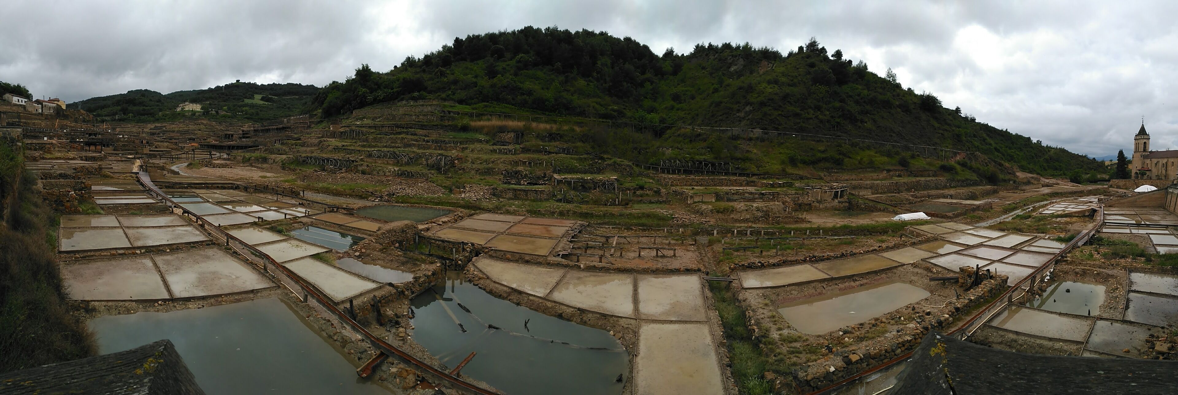 Terraced fields, a river, and a church on a hillside.