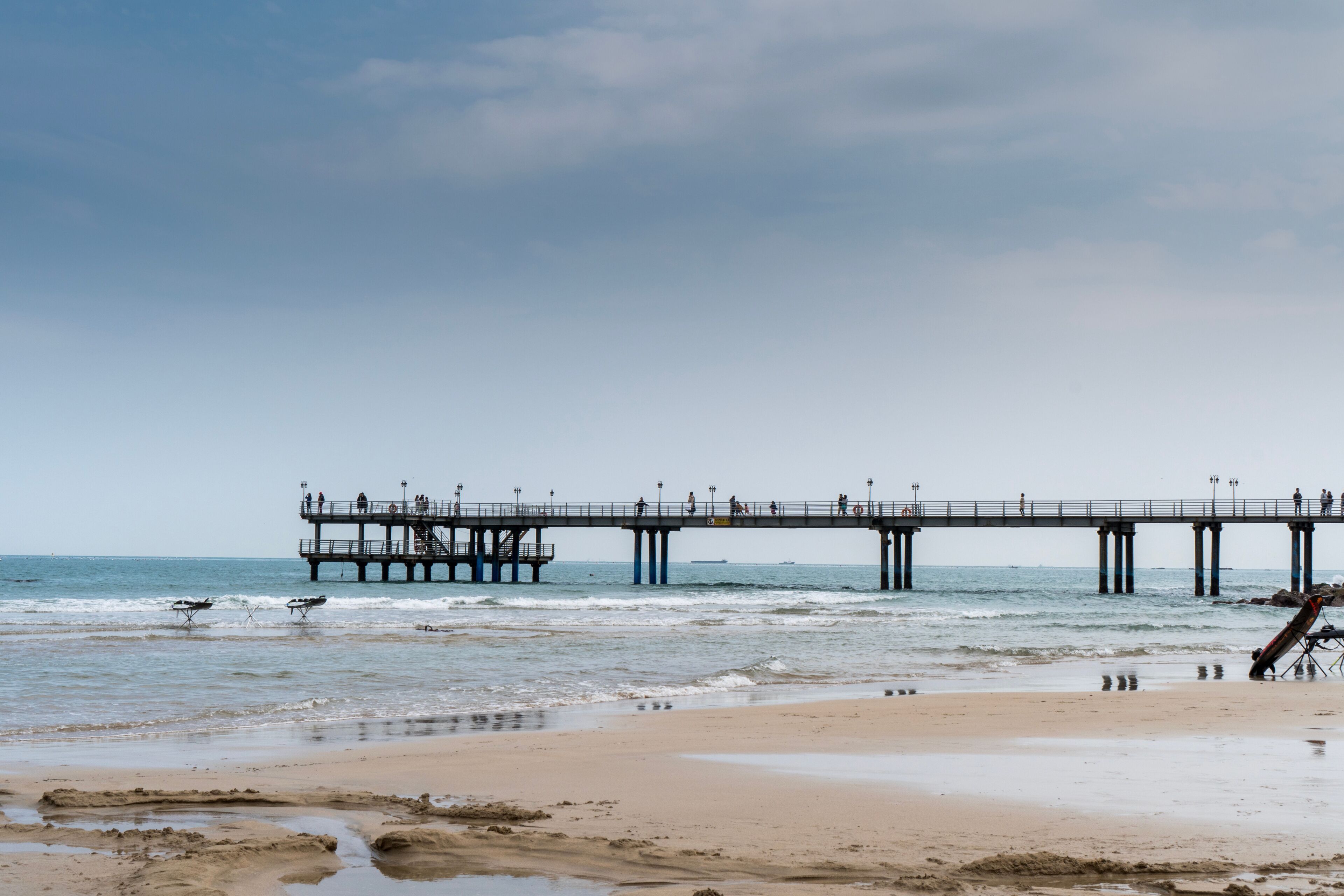 A pier extending into the ocean with people walking along it.
