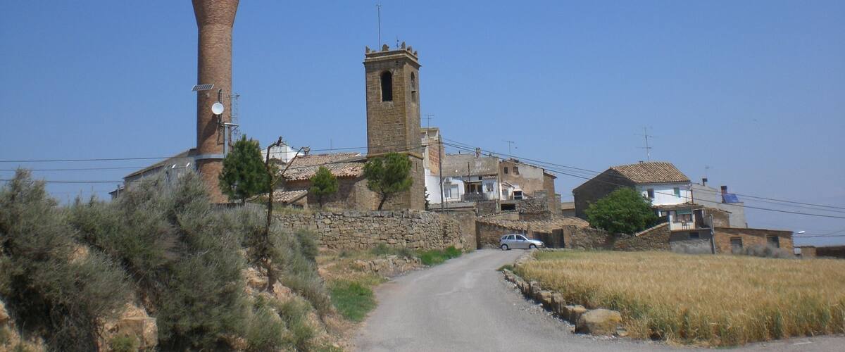 A rural village with a tall brick water tower and a stone tower.