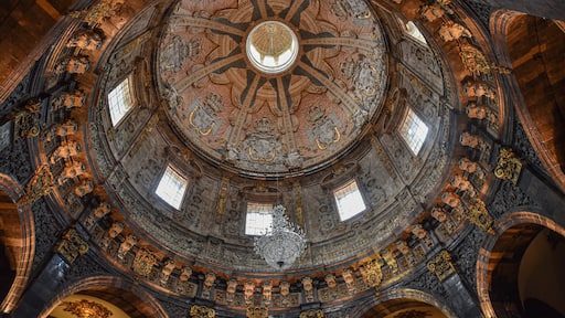 Dettaglio di un soffitto a cupola con elaborate decorazioni intagliate e un motivo circolare centrale.