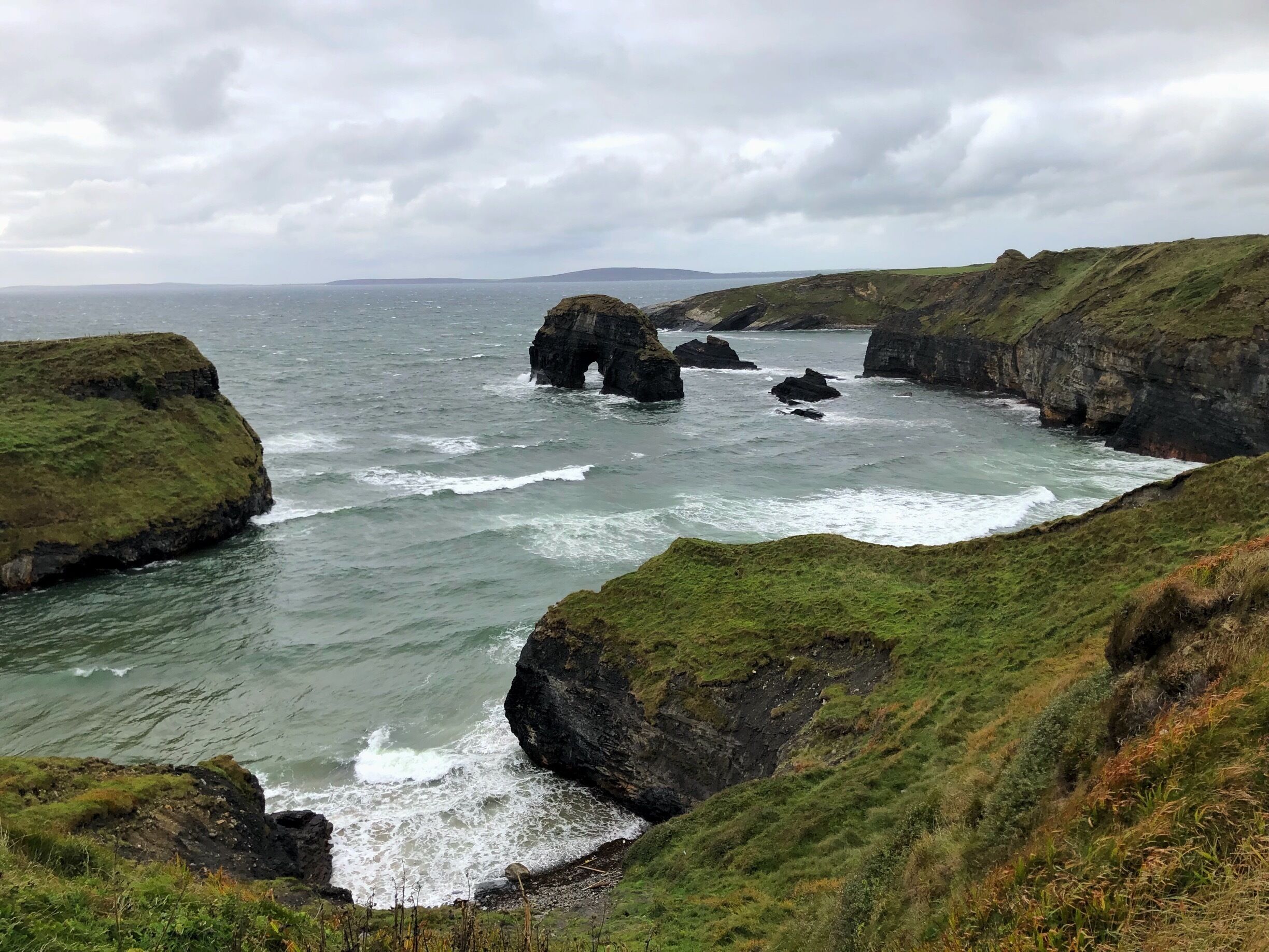 A rugged coastline with rocky cliffs and a narrow sea passage.