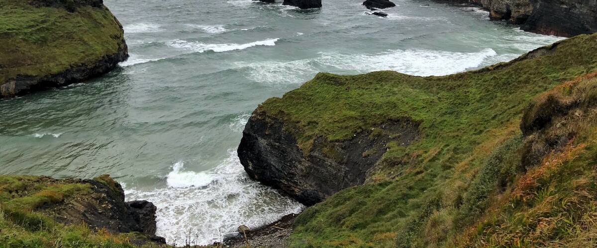 A rugged coastline with rocky cliffs and a narrow sea passage.