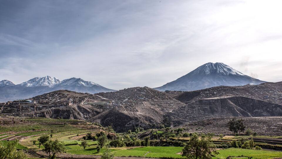 A mountainous landscape with terraced fields and a village.