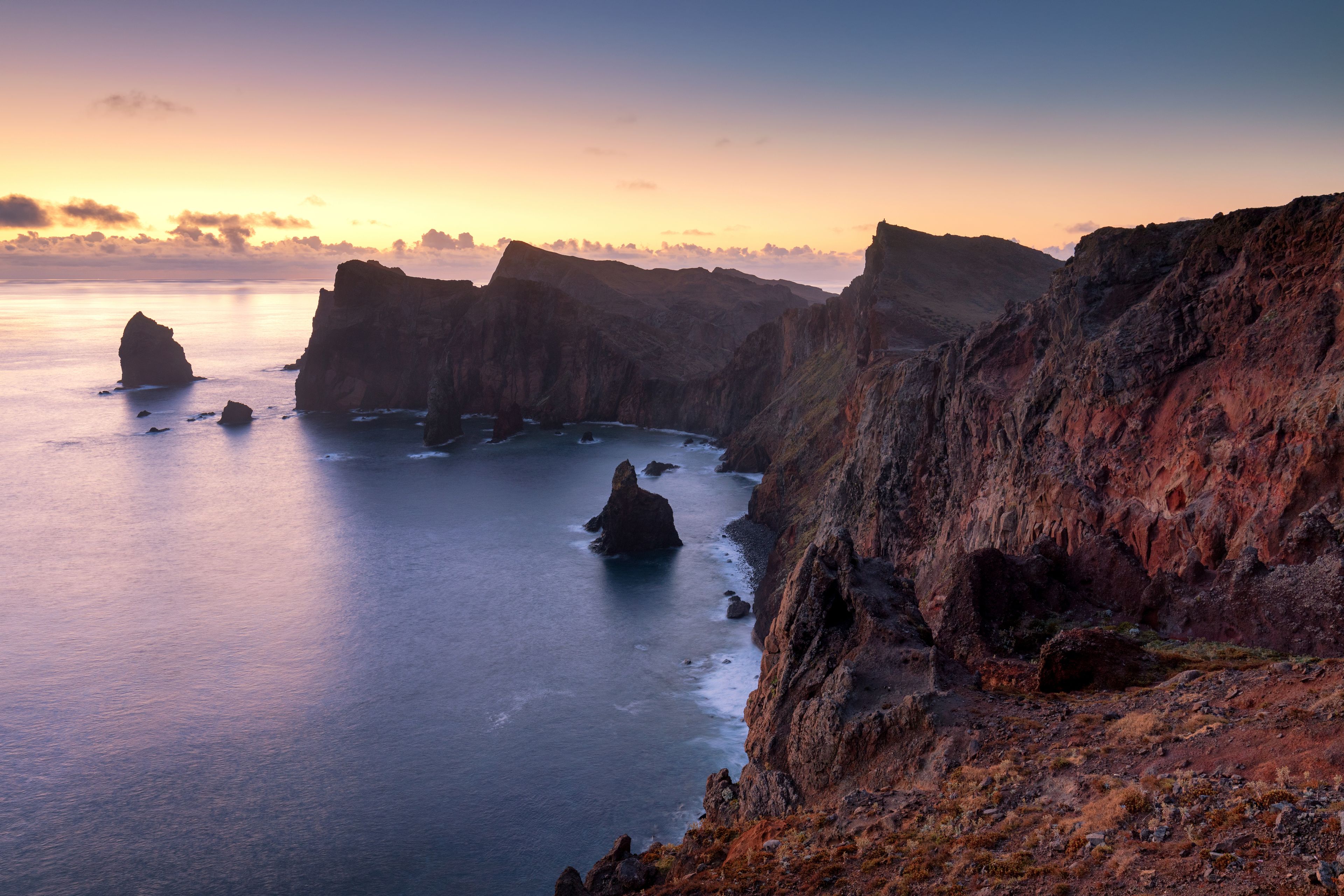 Un paysage côtier caractérisé par des falaises abruptes et des affleurements rocheux.
