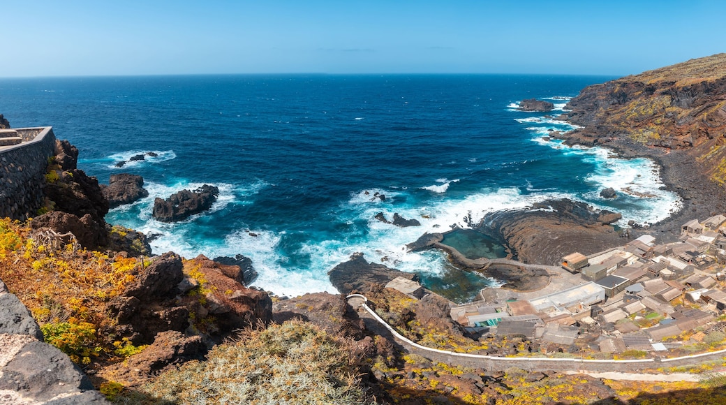 A coastal village with rocky cliffs, the ocean, and a winding road.