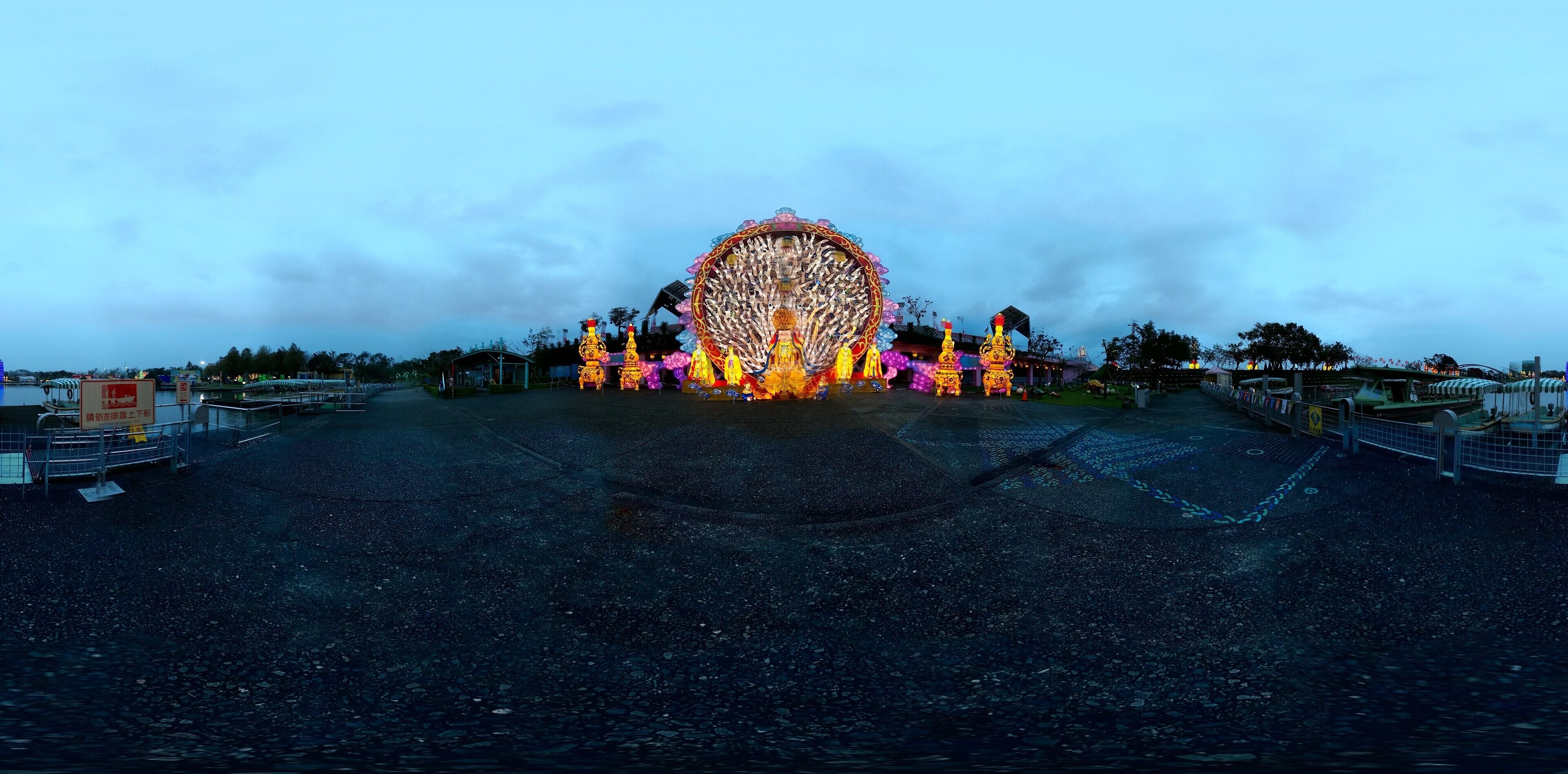 A Ferris wheel with colorful lights and decorations at dusk.