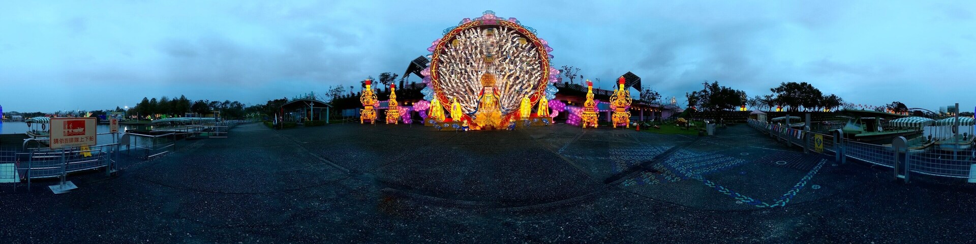A Ferris wheel with colorful lights and decorations at dusk.