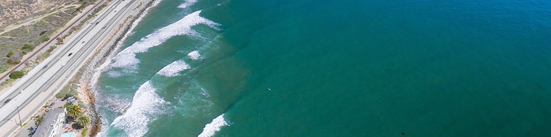 A coastal highway with cliffs and ocean waves.