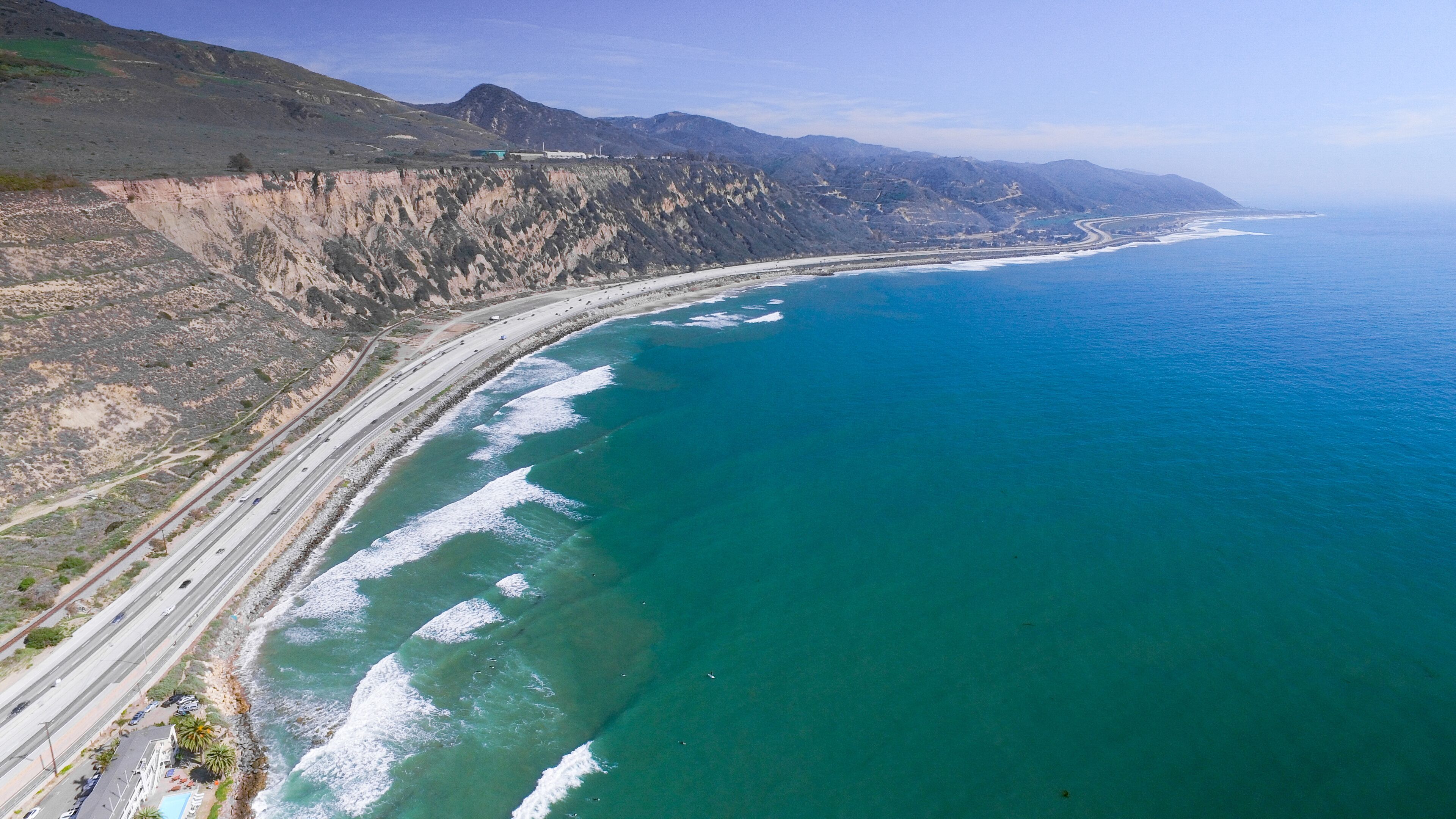 A coastal highway with cliffs and ocean waves.