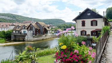 A riverside village with traditional houses, a bridge, and a river.