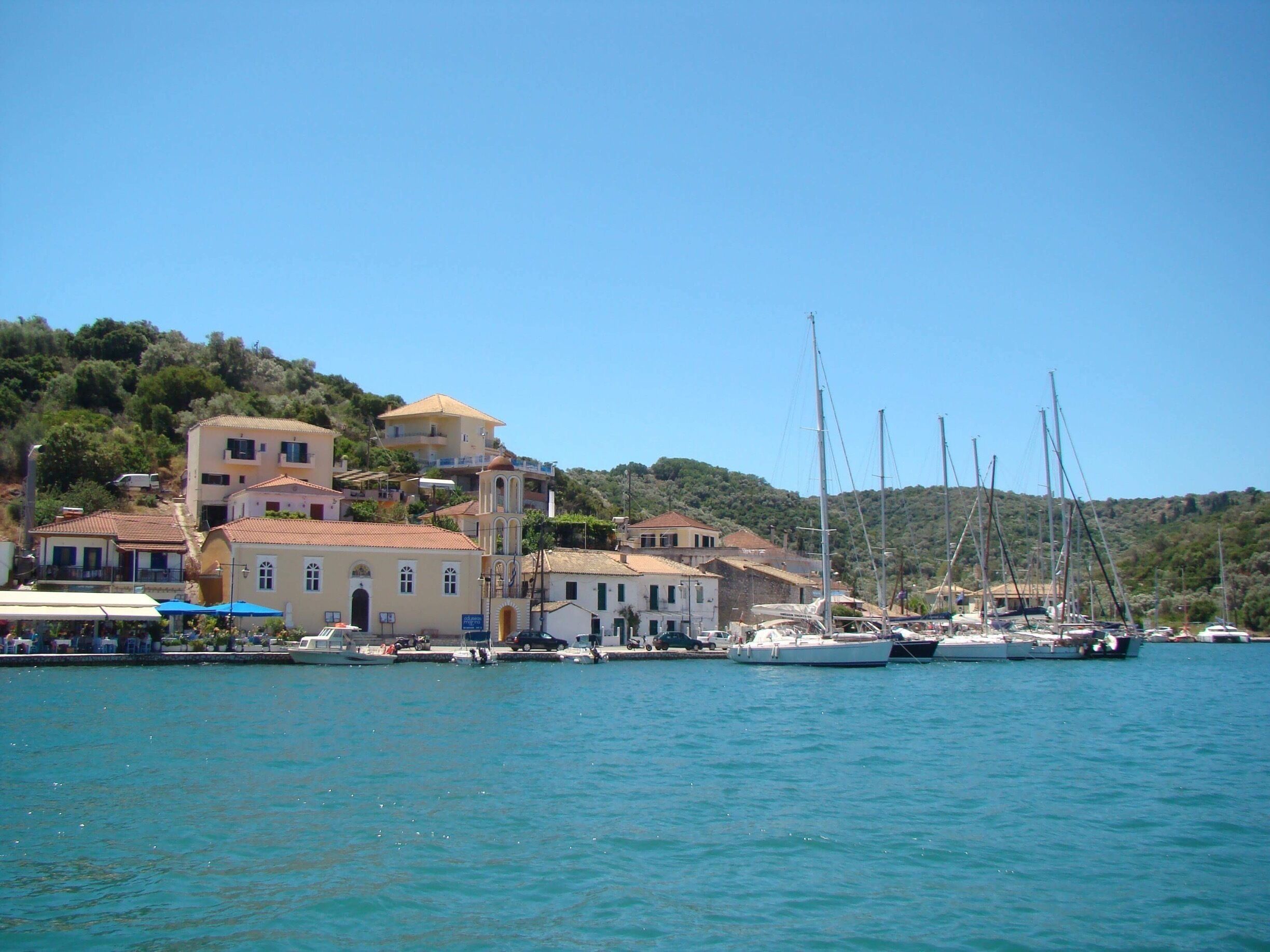 A coastal town with buildings, a dock, and sailboats.