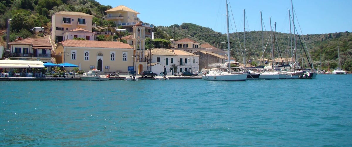 A coastal town with buildings, a dock, and sailboats.
