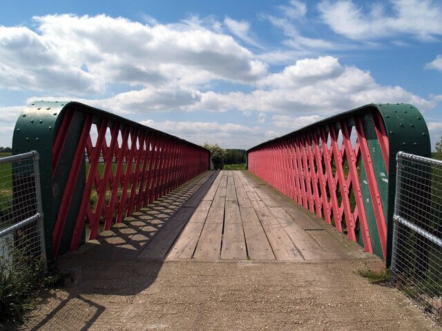 A red metal bridge with a wooden walkway.