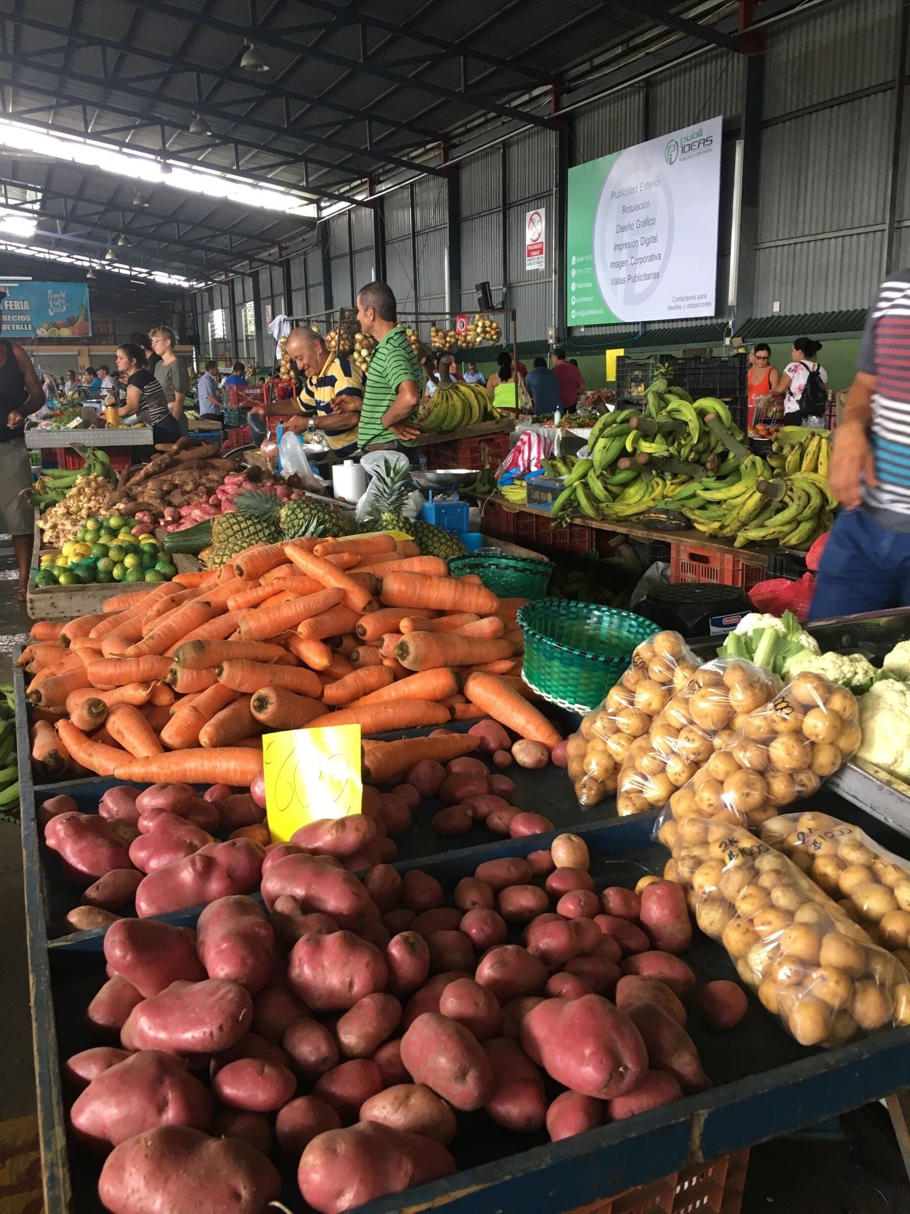 A market with various vegetables like carrots, potatoes, and bananas.