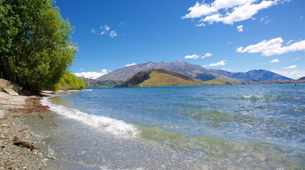 Wanaka som viser en sø eller et vandhul, en stenstrand og bjerge