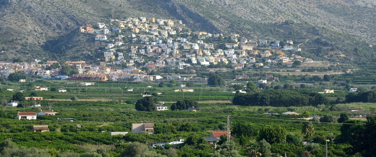 A town nestled in a valley with mountains in the background.