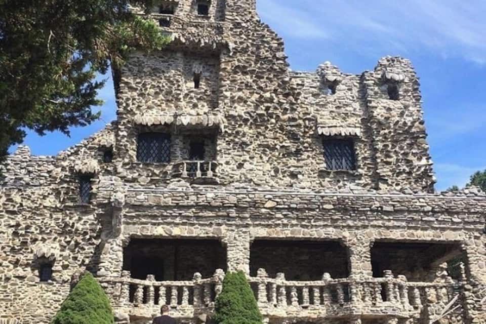 A large, ancient stone building with multiple windows and a central staircase.