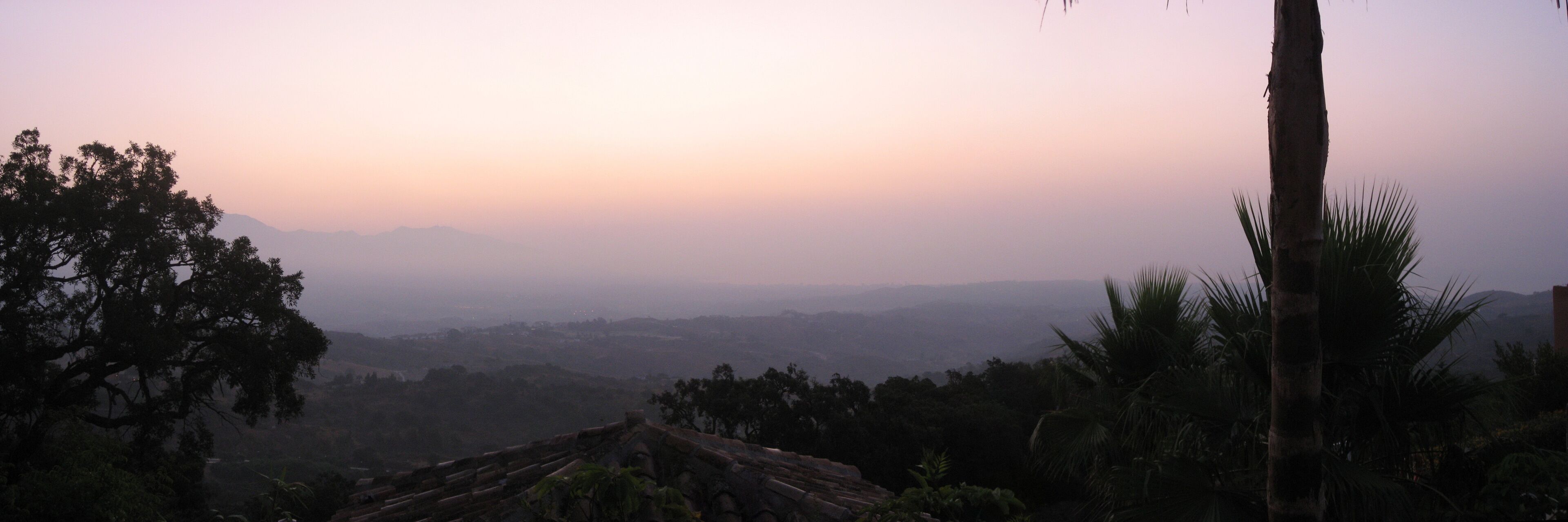 A misty landscape with a view of distant mountains and a clear sky.