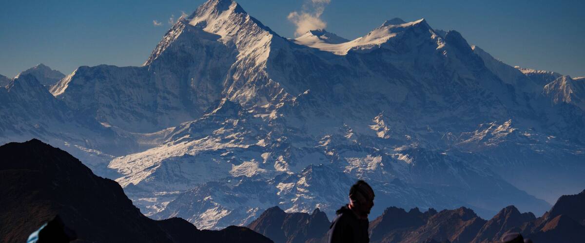 A mountainous landscape with a prominent peak and rocky terrain.