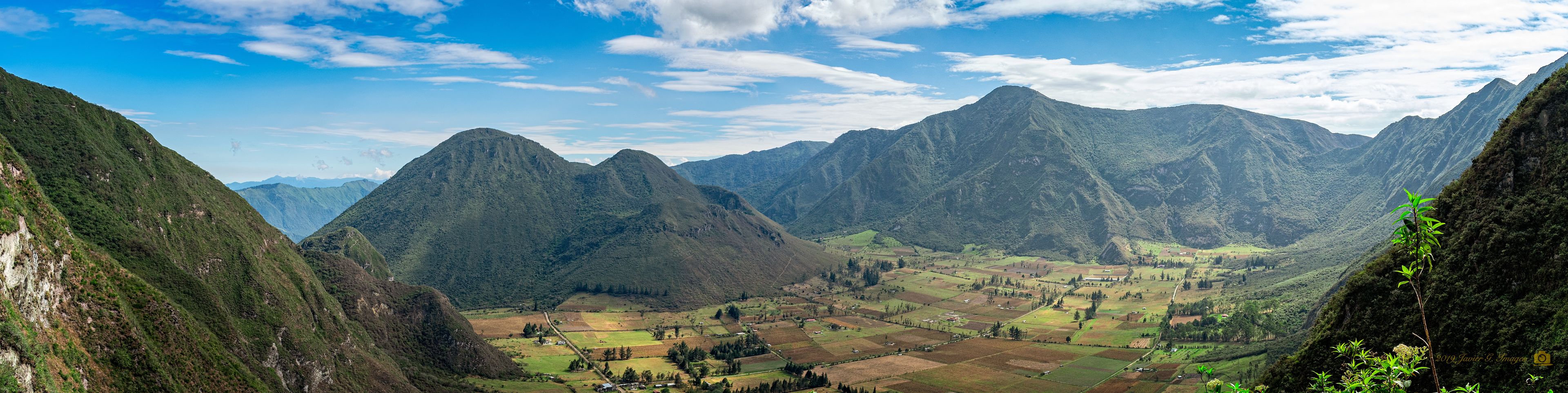 A mountainous landscape with terraced fields and a clear sky.