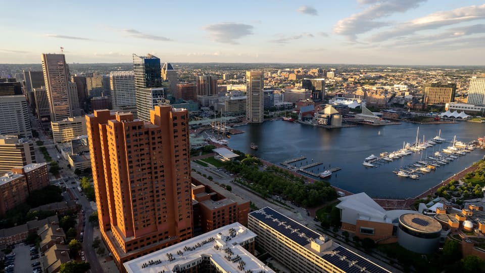 A cityscape with a marina filled with boats, high-rise buildings, and a river.