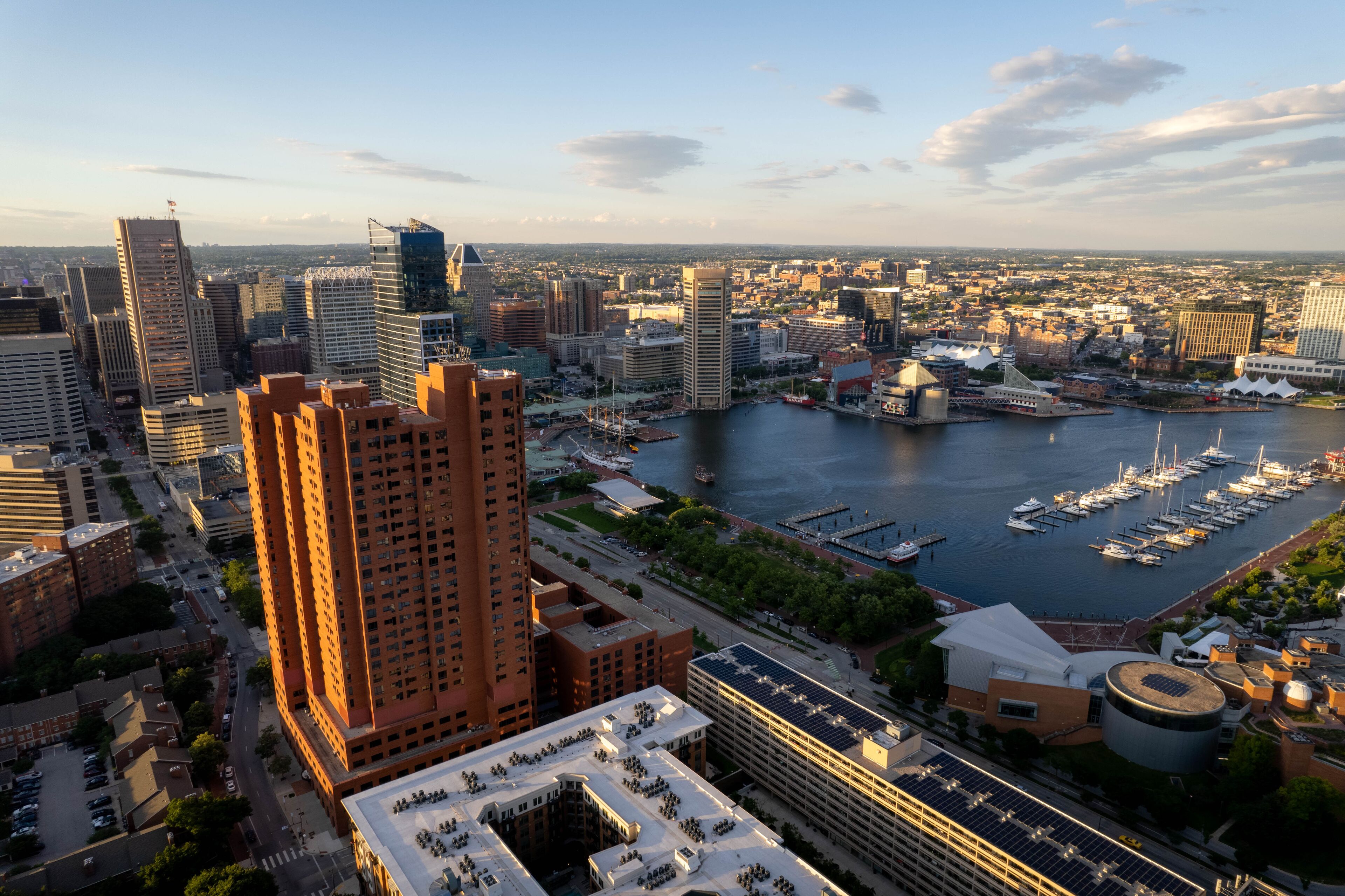 A cityscape with a marina filled with boats, high-rise buildings, and a river.