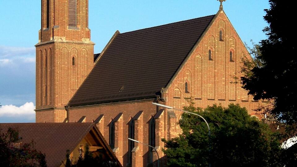 A church with a tall steeple and a clock.