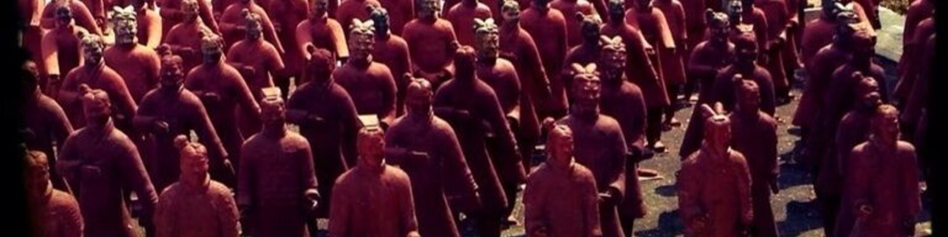 Un grupo numeroso de personas vestidas de rojo formando filas en una ladera.