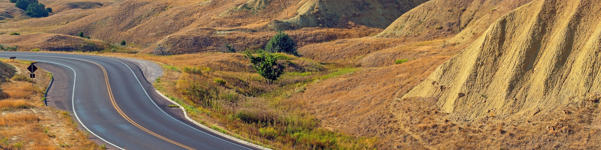 Yellow Mounds with highway in summer, Badlands national park, South Dakota, USA.