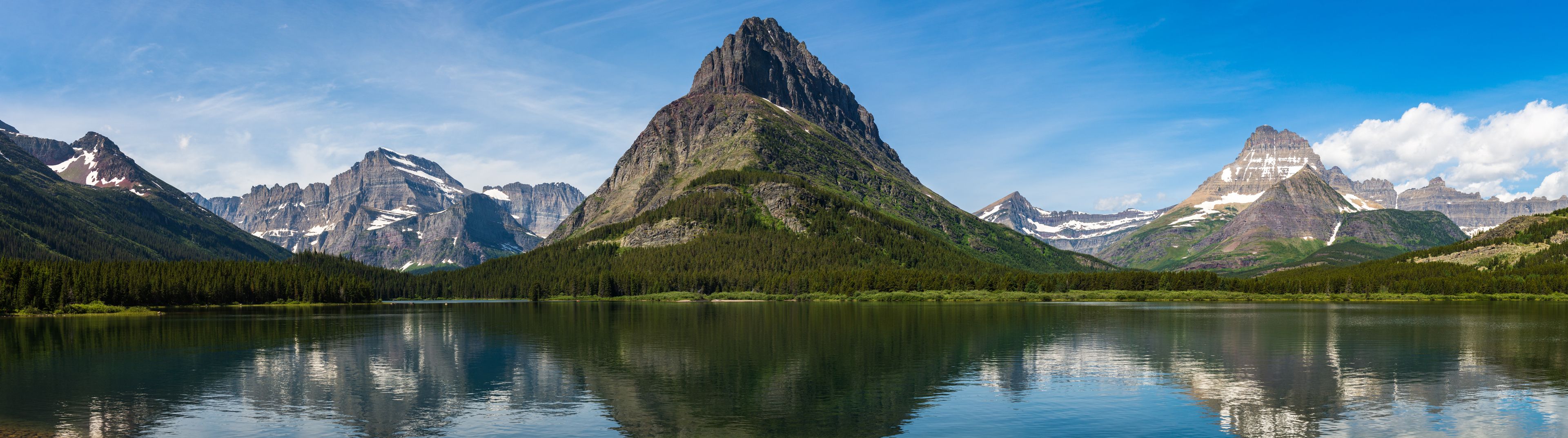 A mountain lake with reflections of the surrounding peaks.