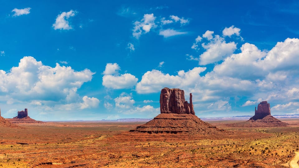 A desert landscape with red rock formations and a clear blue sky.