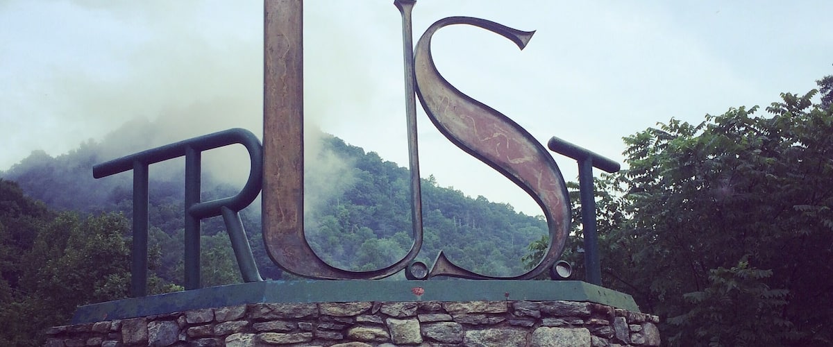 A stone wall with the word "TRUST" in large letters.