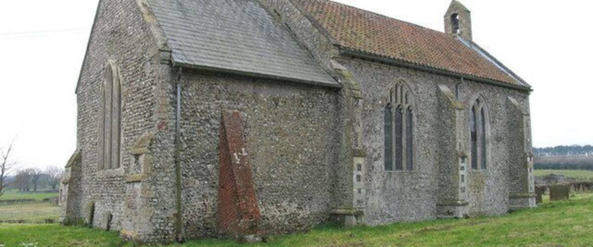 A stone church with a tiled roof and a bell tower.