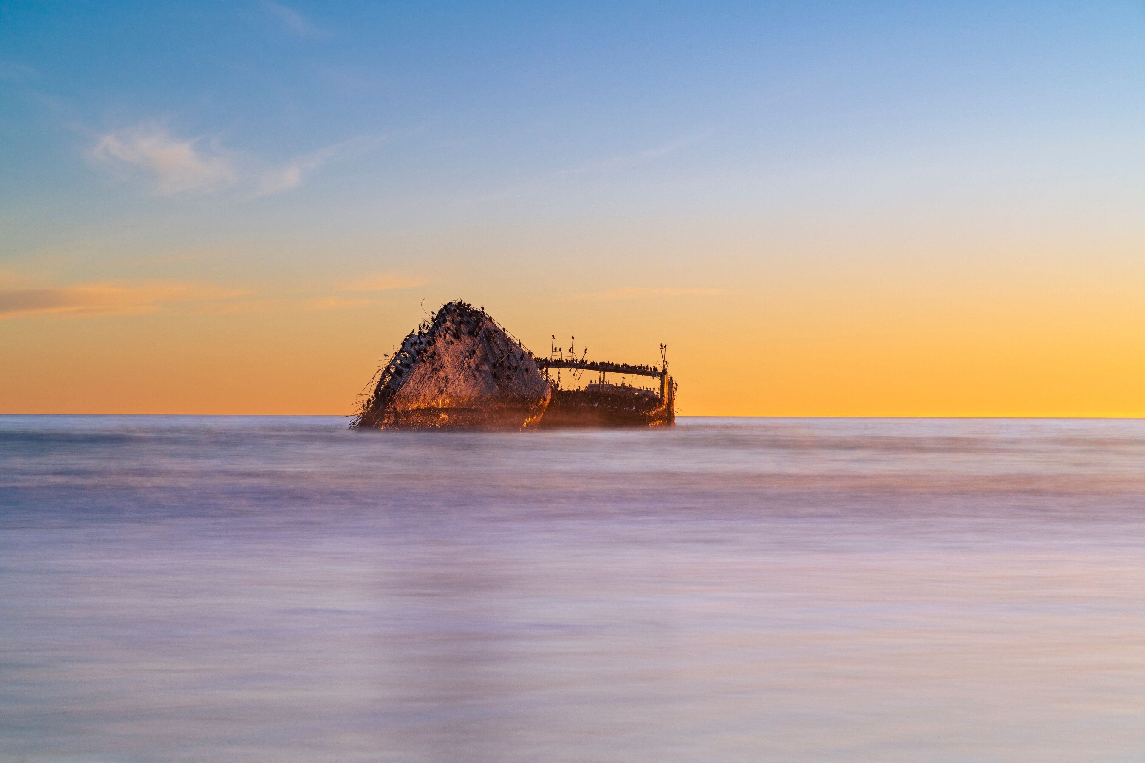 The SS Palo Alto bathed in the warm, golden glow of the sunset at Seacliff State Park Beach.