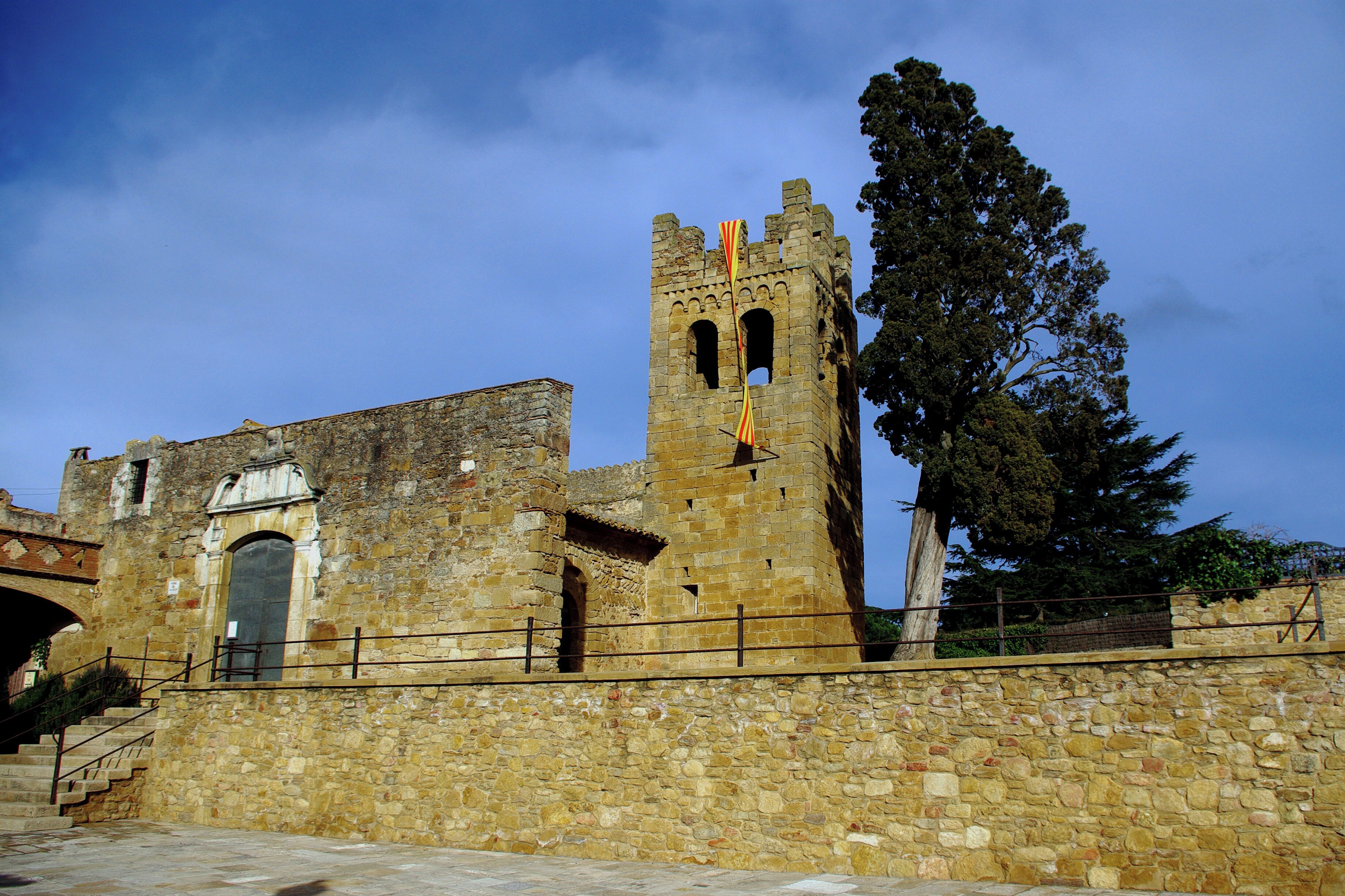 A historic stone building with a tall tower and a flag.