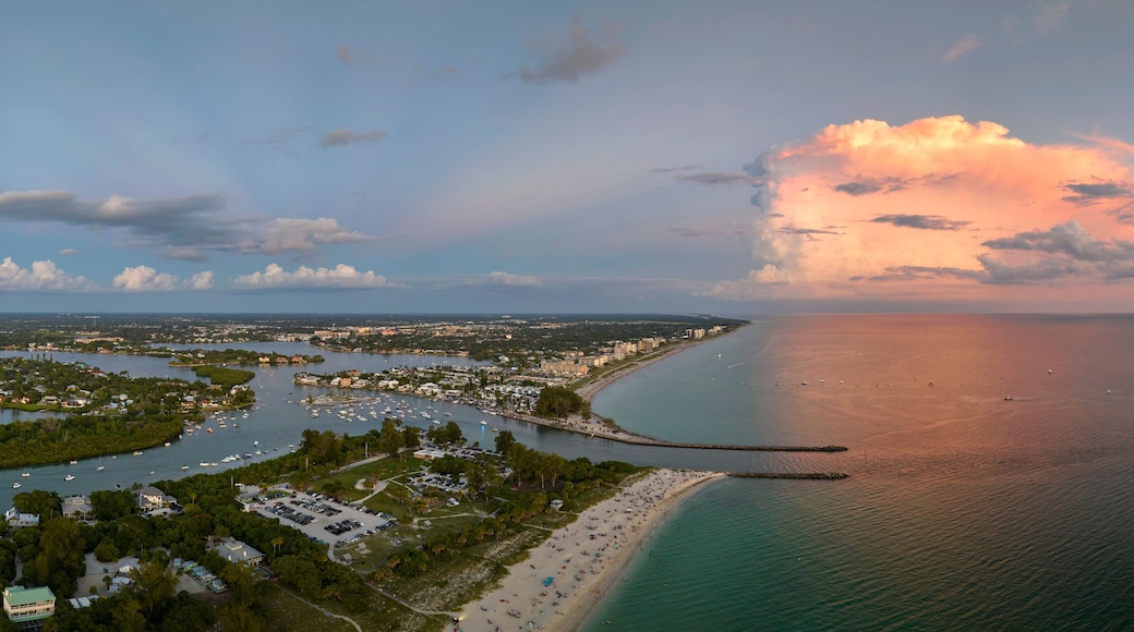 Aerial view of sea shore near Venice, Florida with white yachts at sunset floating on sea waves. North and South Jetty on Nokomis beach. Motor boat recreation on ocean surface