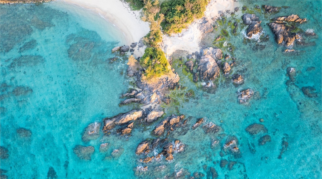 Ein tĂŒrkisfarbenes Meer mit Felsen und einem Sandstrand.